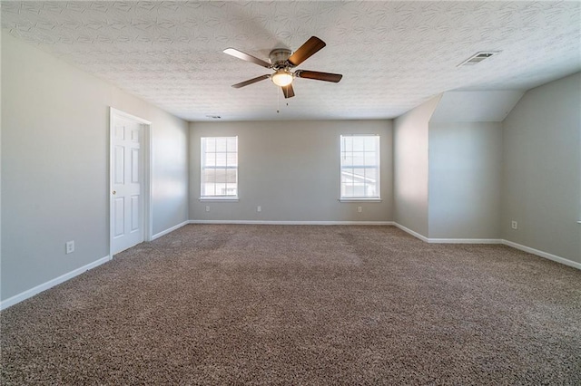 carpeted spare room with ceiling fan, a textured ceiling, visible vents, and baseboards