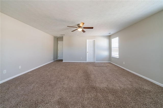 spare room with a textured ceiling, carpet floors, ceiling fan, and baseboards