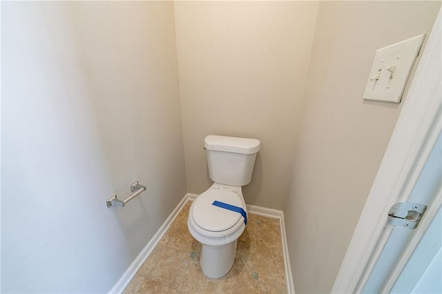 bathroom featuring toilet and baseboards