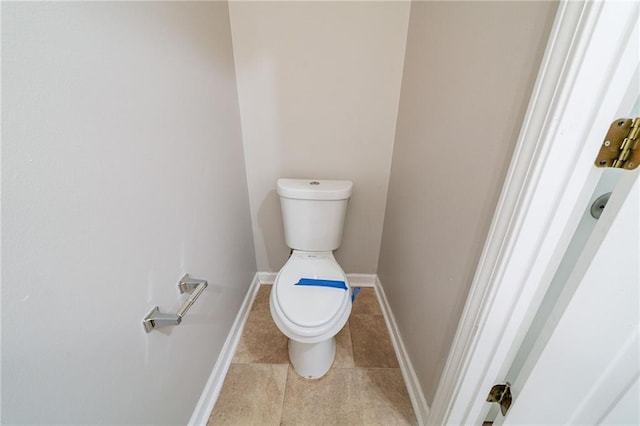 bathroom featuring toilet, tile patterned flooring, and baseboards