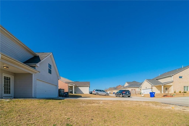 view of yard featuring a garage and a residential view