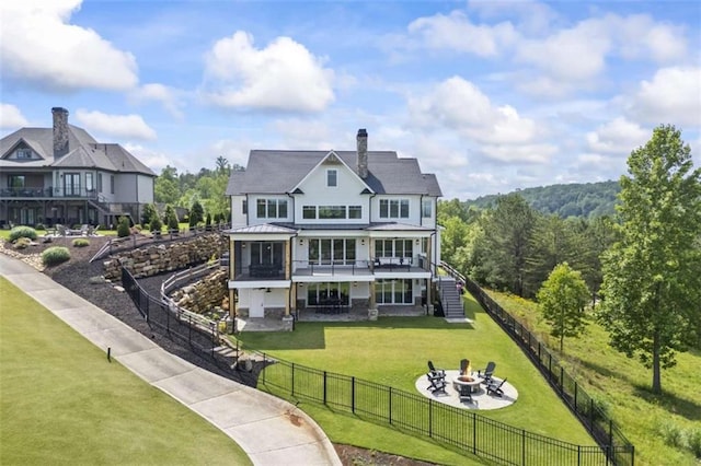 back of property featuring a yard, a patio, and a fire pit