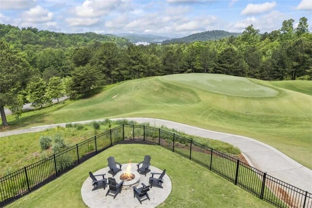 view of home's community with a patio, a fire pit, and a lawn