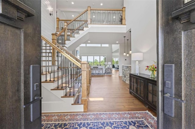 foyer entrance with hardwood / wood-style floors and a high ceiling