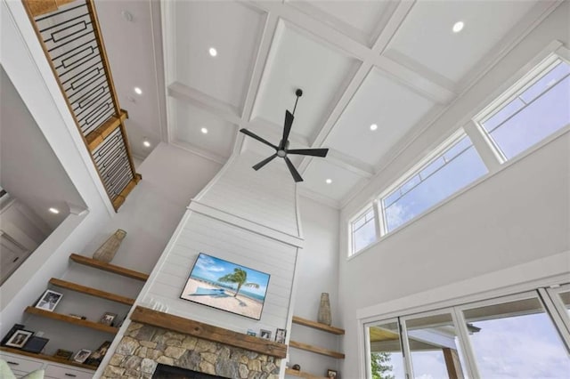 room details featuring beam ceiling, ceiling fan, a fireplace, and coffered ceiling