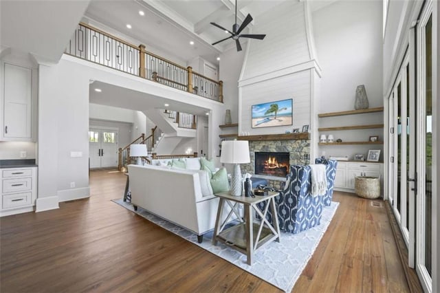 living room featuring beam ceiling, a fireplace, wood-type flooring, and coffered ceiling