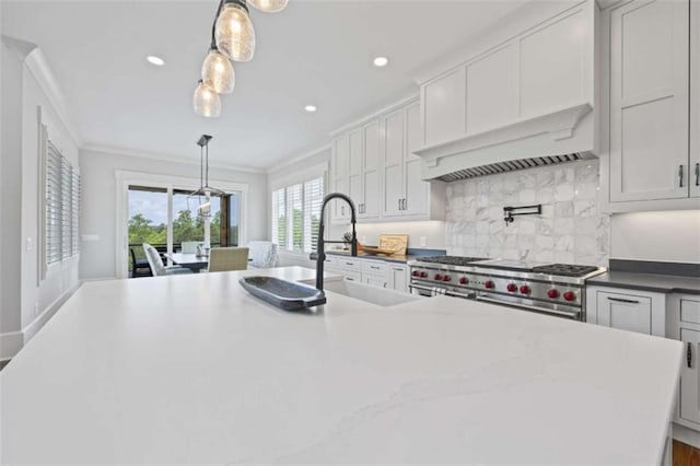 kitchen with white cabinetry, sink, hanging light fixtures, and range with two ovens