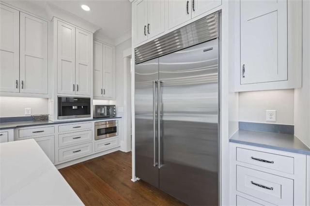 kitchen with dark hardwood / wood-style flooring, white cabinetry, and built in fridge