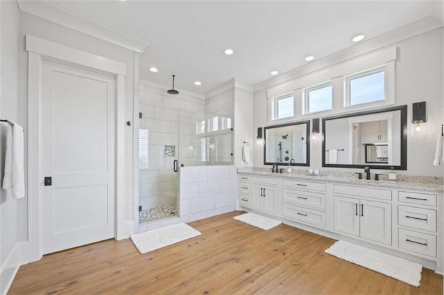 bathroom with vanity, a shower with shower door, and hardwood / wood-style flooring