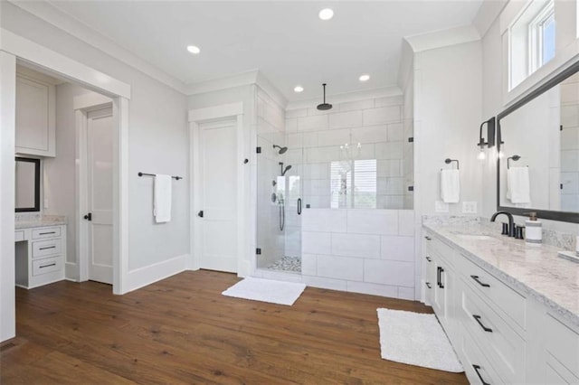 bathroom featuring hardwood / wood-style floors, vanity, ornamental molding, and walk in shower