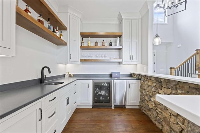 bar with dark hardwood / wood-style flooring, sink, white cabinets, and beverage cooler