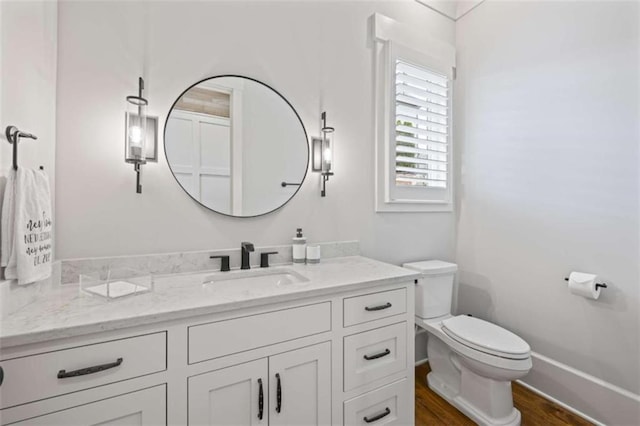 bathroom featuring vanity, hardwood / wood-style flooring, and toilet