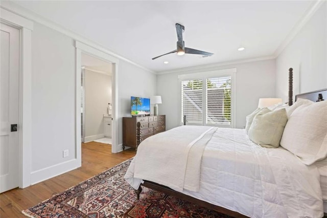 bedroom with connected bathroom, light hardwood / wood-style floors, ceiling fan, and ornamental molding