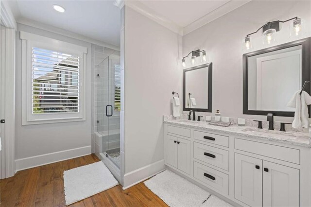 bathroom with hardwood / wood-style floors, vanity, an enclosed shower, and ornamental molding