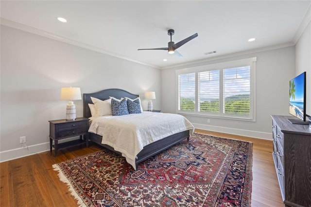 bedroom with dark hardwood / wood-style flooring, ceiling fan, and ornamental molding