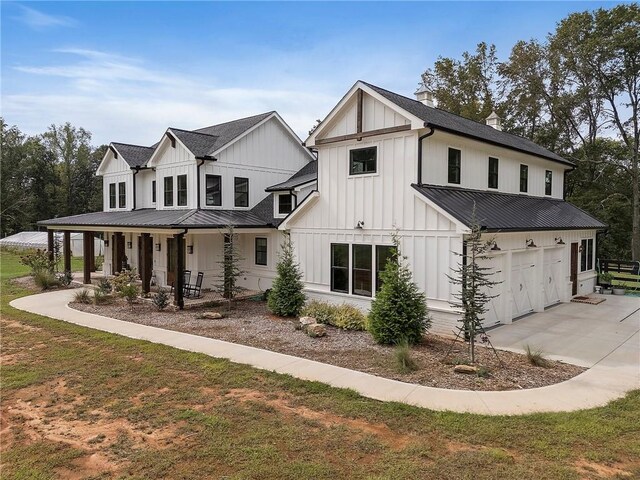 modern farmhouse style home featuring a porch, a garage, and a front lawn