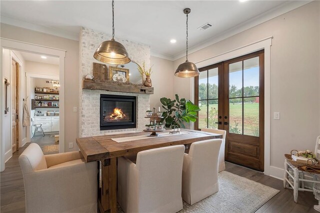 dining area featuring a fireplace, french doors, dark hardwood / wood-style floors, and ornamental molding