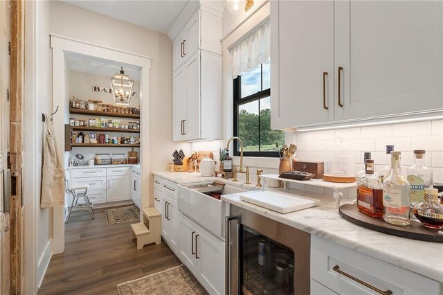 kitchen with dark hardwood / wood-style flooring, white cabinetry, sink, and beverage cooler