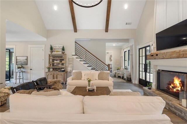 living room featuring beamed ceiling, high vaulted ceiling, and light wood-type flooring