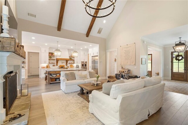 living room with beamed ceiling, a notable chandelier, high vaulted ceiling, and light hardwood / wood-style flooring