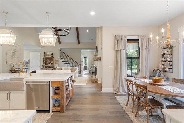 kitchen featuring pendant lighting, sink, white cabinets, and stainless steel dishwasher