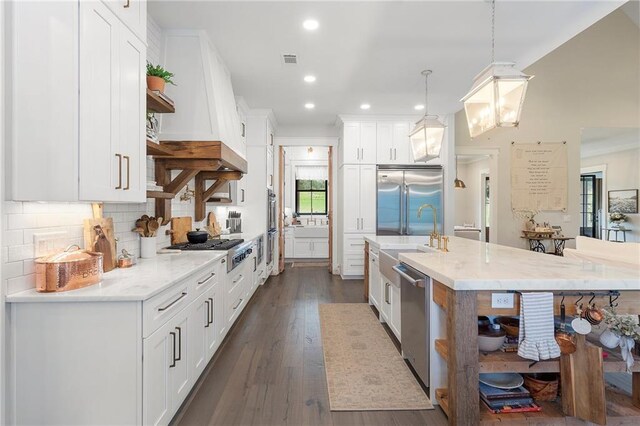 kitchen with stainless steel appliances, white cabinetry, and hanging light fixtures