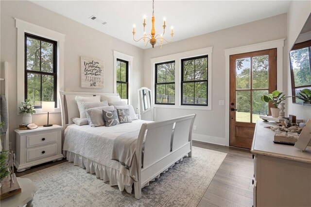 bedroom featuring light hardwood / wood-style flooring, multiple windows, and a notable chandelier