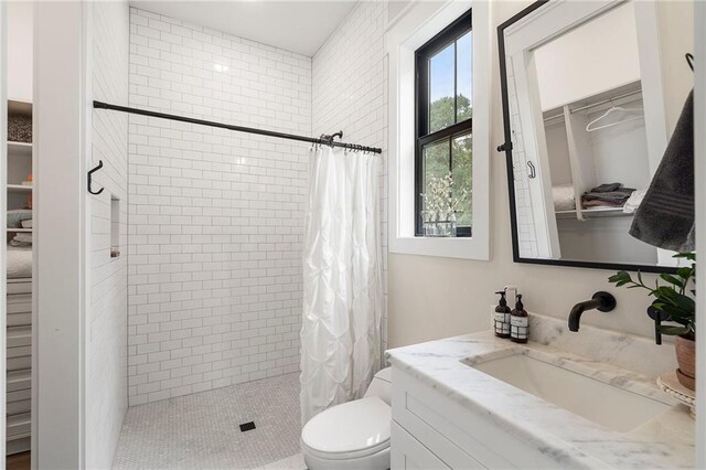 bathroom featuring tile patterned flooring, a shower with curtain, toilet, and vanity