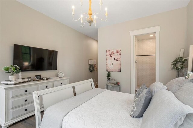 bedroom featuring ensuite bathroom, dark hardwood / wood-style floors, and an inviting chandelier