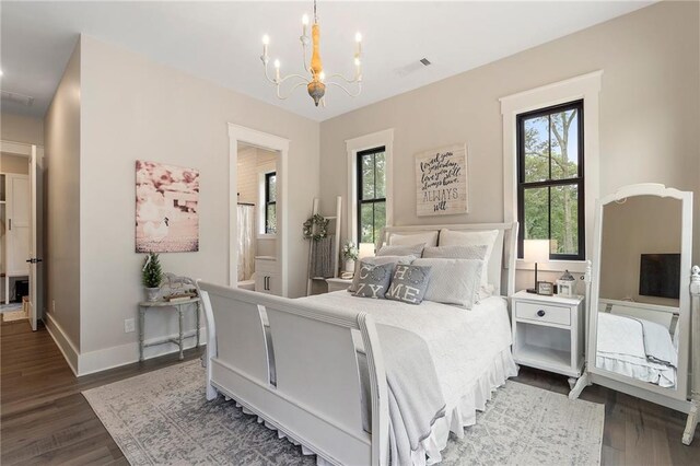 bedroom with a notable chandelier and dark wood-type flooring