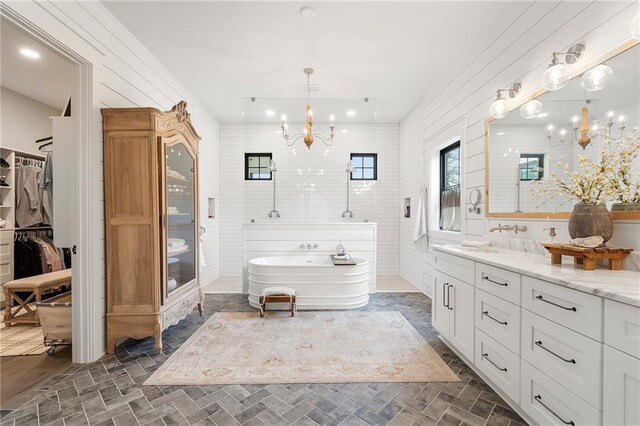 bathroom featuring a bathing tub, vanity, and an inviting chandelier