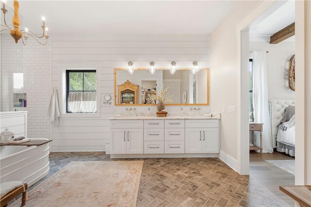 bathroom with wooden walls, vanity, and an inviting chandelier