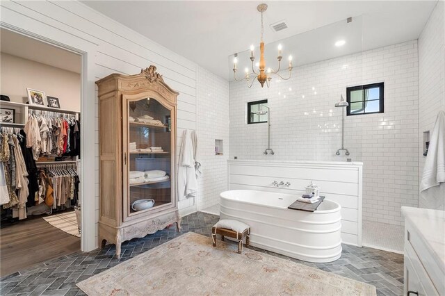 bathroom with shower with separate bathtub, a notable chandelier, and hardwood / wood-style floors