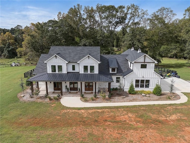 modern inspired farmhouse featuring covered porch and a front lawn