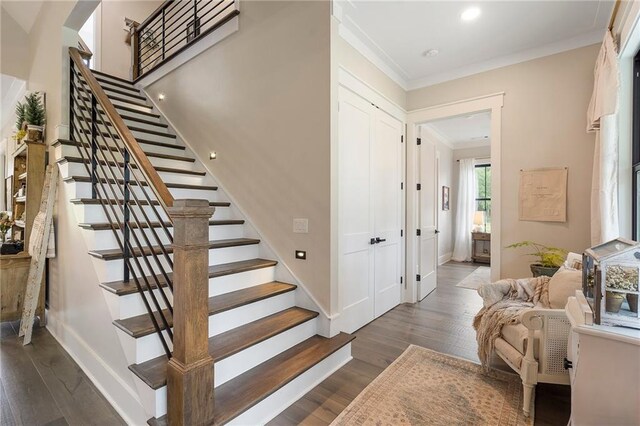 stairway with crown molding and hardwood / wood-style floors