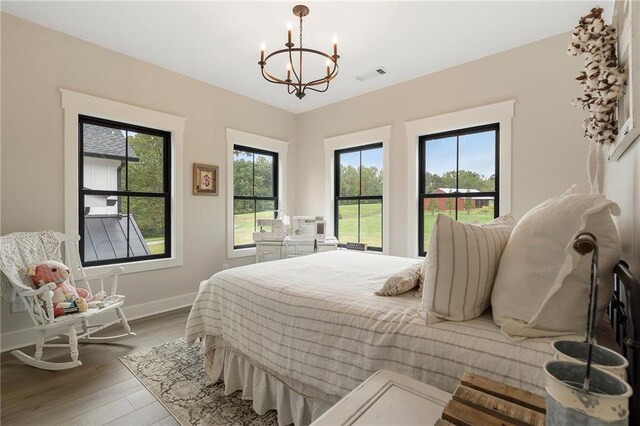 bedroom with hardwood / wood-style floors and a notable chandelier