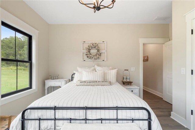 bedroom with dark hardwood / wood-style flooring and a chandelier