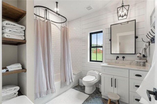 full bathroom featuring shower / bath combo, toilet, vanity, and an inviting chandelier