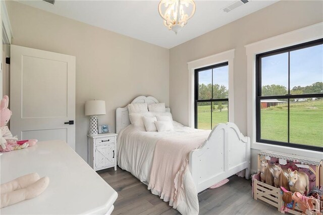 bedroom featuring dark hardwood / wood-style floors and a notable chandelier