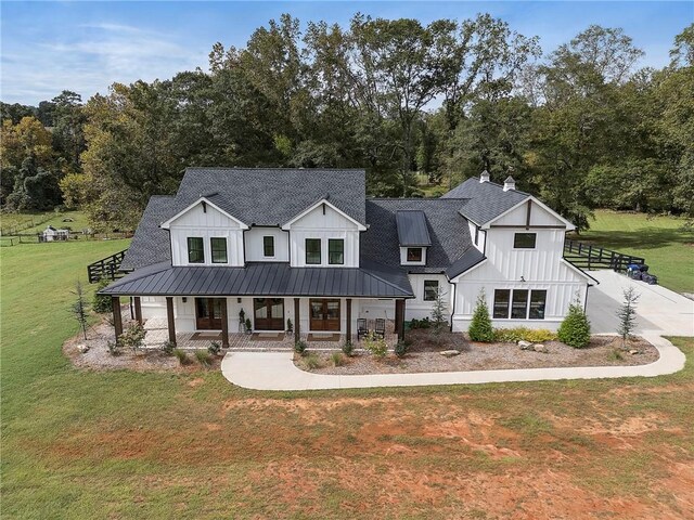 modern farmhouse style home featuring a front lawn and covered porch