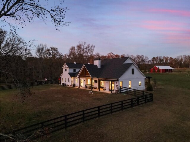 view of front of property featuring a lawn and a patio