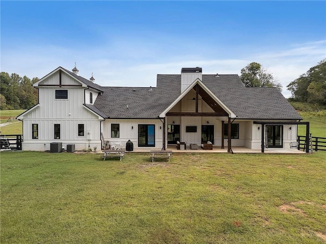 back of house with central AC, a yard, and a patio