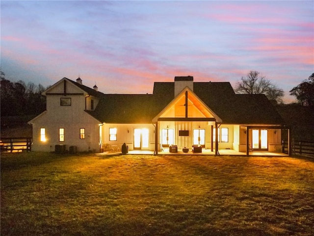 back house at dusk featuring a patio