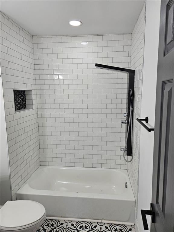 bathroom with toilet and tiled shower / bath