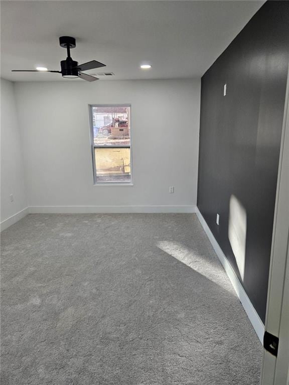 carpeted spare room featuring ceiling fan