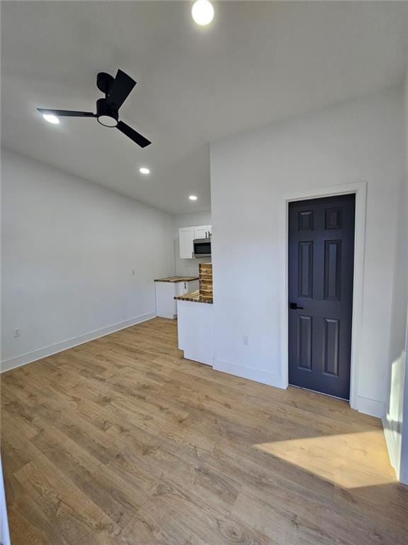 unfurnished living room with ceiling fan and light hardwood / wood-style flooring