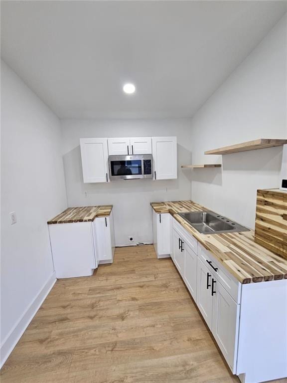 kitchen with white cabinetry and butcher block counters