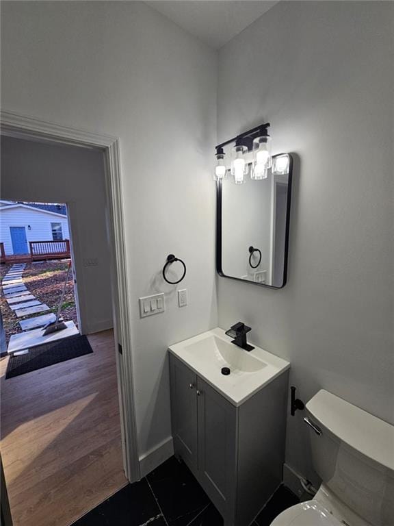 bathroom with hardwood / wood-style floors, vanity, and toilet