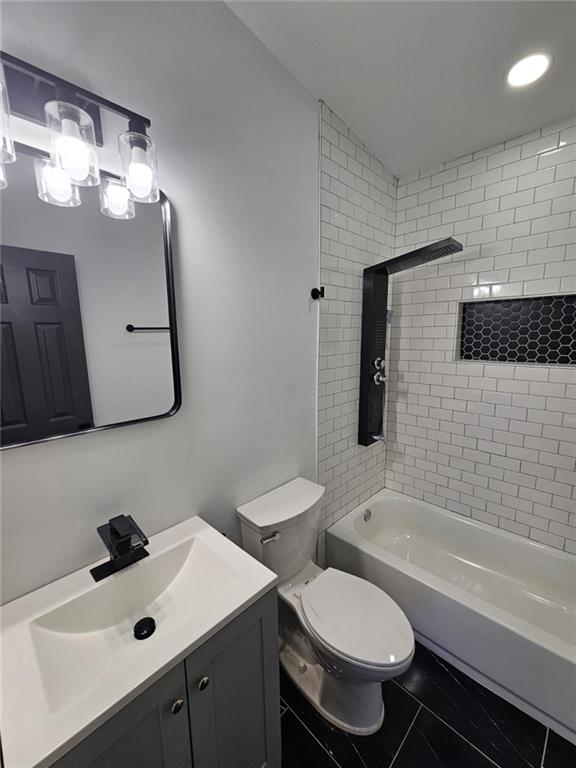 full bathroom with tile patterned flooring, vanity, toilet, and tiled shower / bath