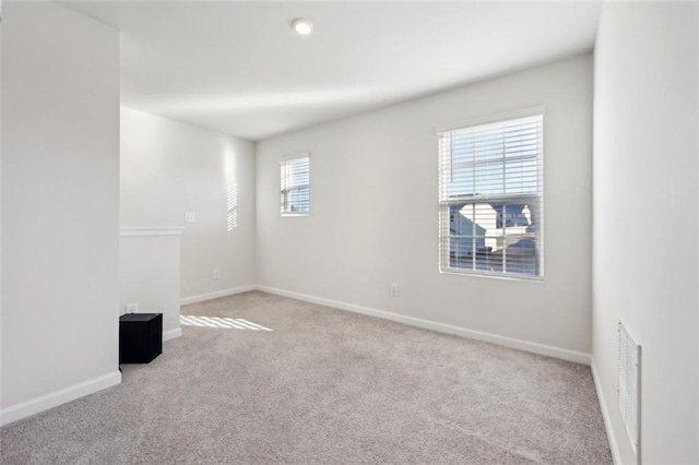 carpeted spare room featuring plenty of natural light